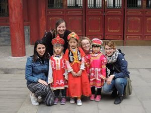 ExkursionsteilnehmerInnen mit einer gruppe chinesischer Kinder in lokaler traditioneller Kleidung.